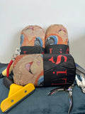 Pair of colorful slippers with a black strap, a yellow tool, and a metal object on a blue surface.