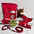 Dog accessories including a red 'Parachute' bag, harness, leash, toy, and plush toy on a white background.