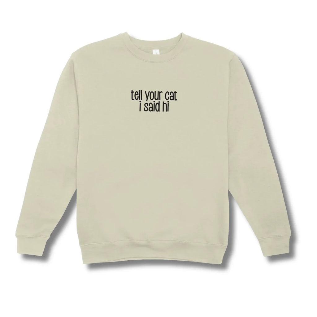 Beige sweatshirt with text 'tell your cat I said hi' on a white background
